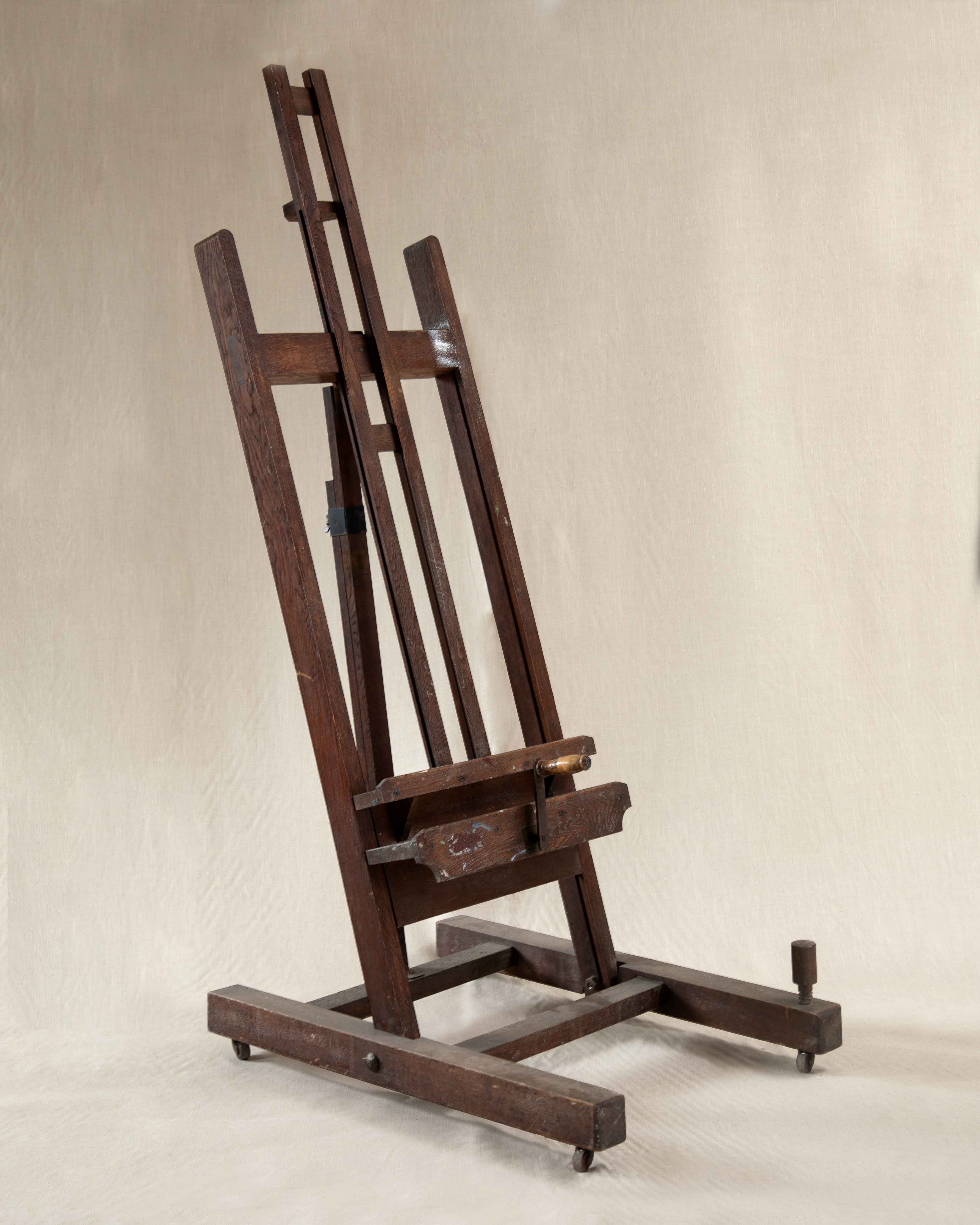 A brown antique artist's easel on a linen backdrop.