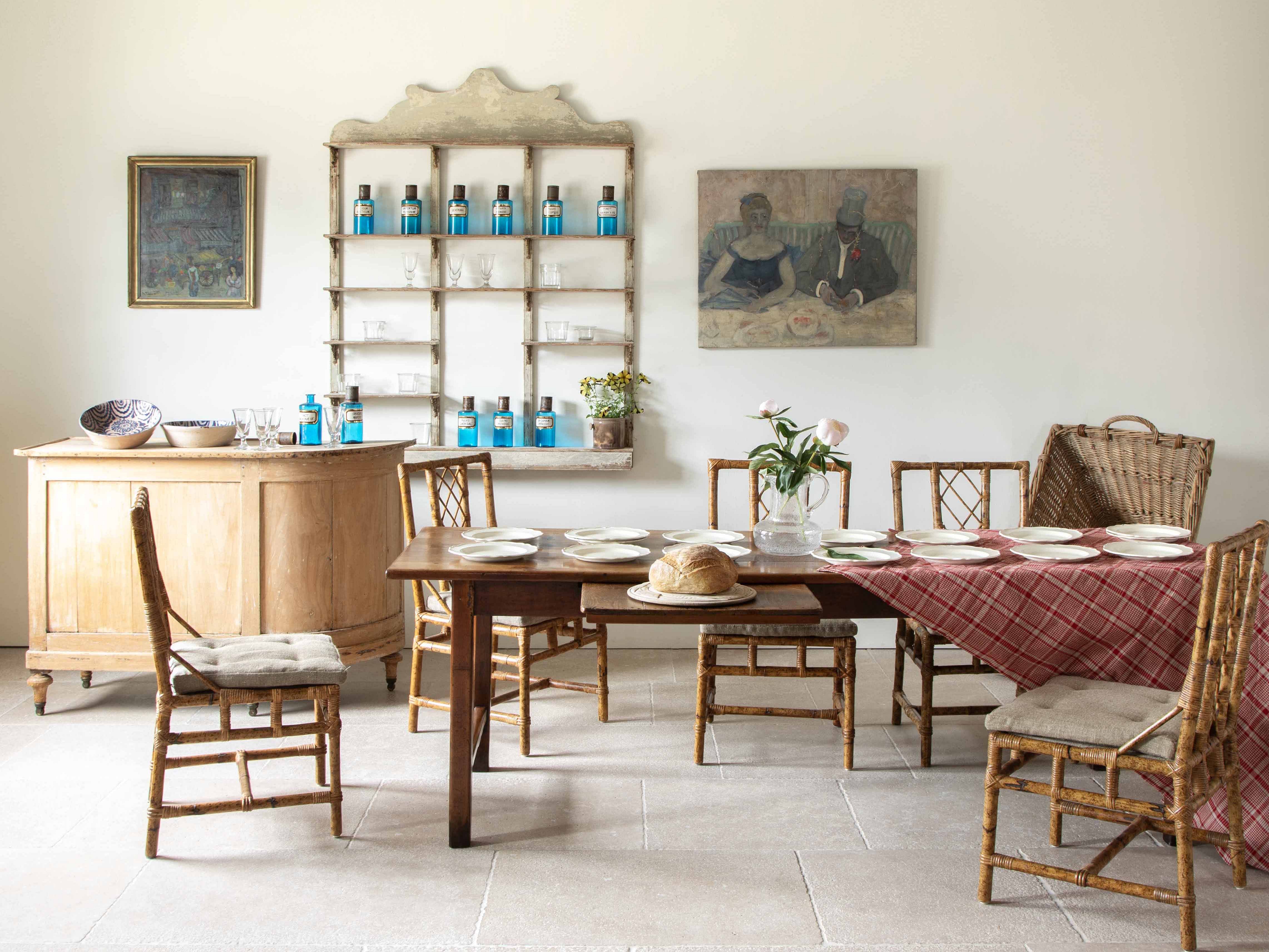 A styled set of a French dining scene including antique furniture and accessories.